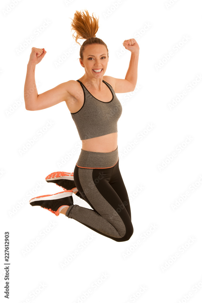 Beautiful young woman jumps gesturing success isolated over white background