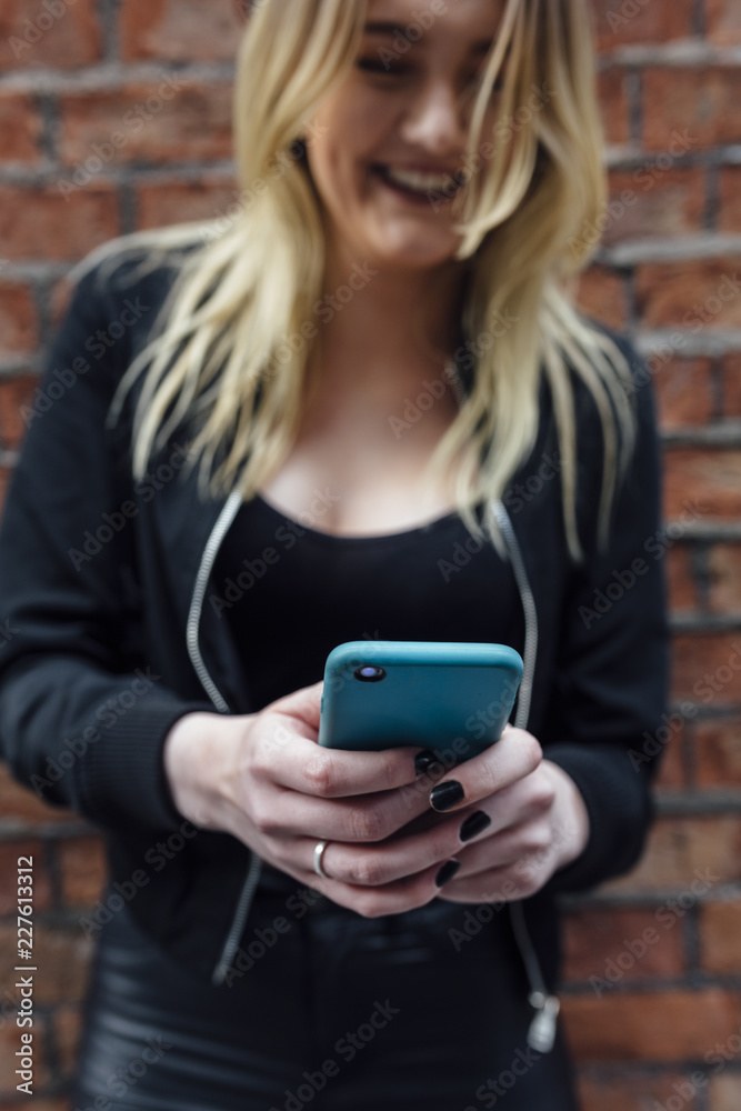 © killer/Stocksy - Young Woman Using a Blue Mobile Phone