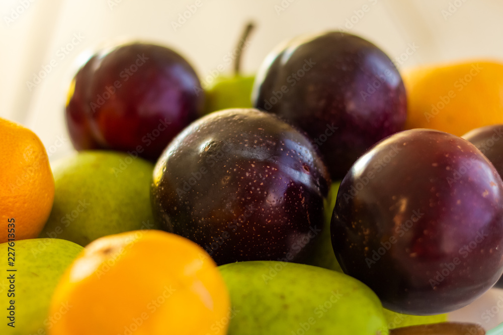 Detail of a fresh plums, mandarins and pears Detail of a fresh plums, mandarins and pears