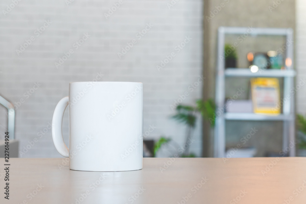 White mug on table and modern room background. Blank drink cup for your design. Can put text, image, and logo. White mug on table and modern room background. Blank drink cup for your design. Can put text, image, and logo.