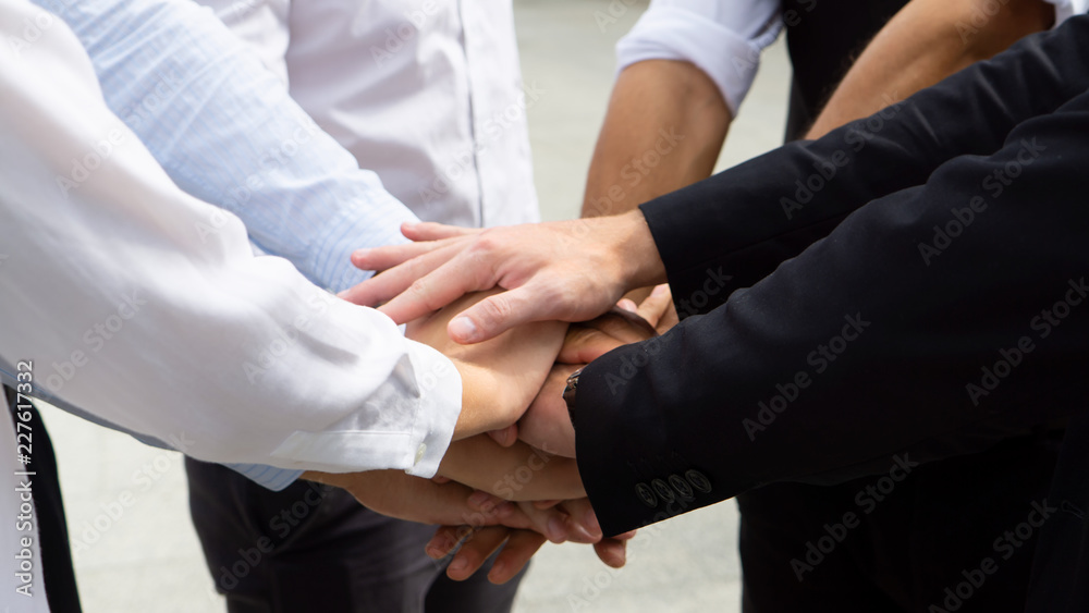 Closeup on hands. Colleague putting their hands on top of each other symbolizing unity and teamwork while doing activity outdoor. People joining hand together as a business goal achievement.