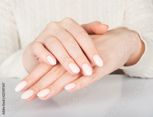 Beautiful female hand with beige nail design.