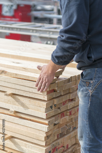 A man works at a sawmill. Man folding boards. vertical photo