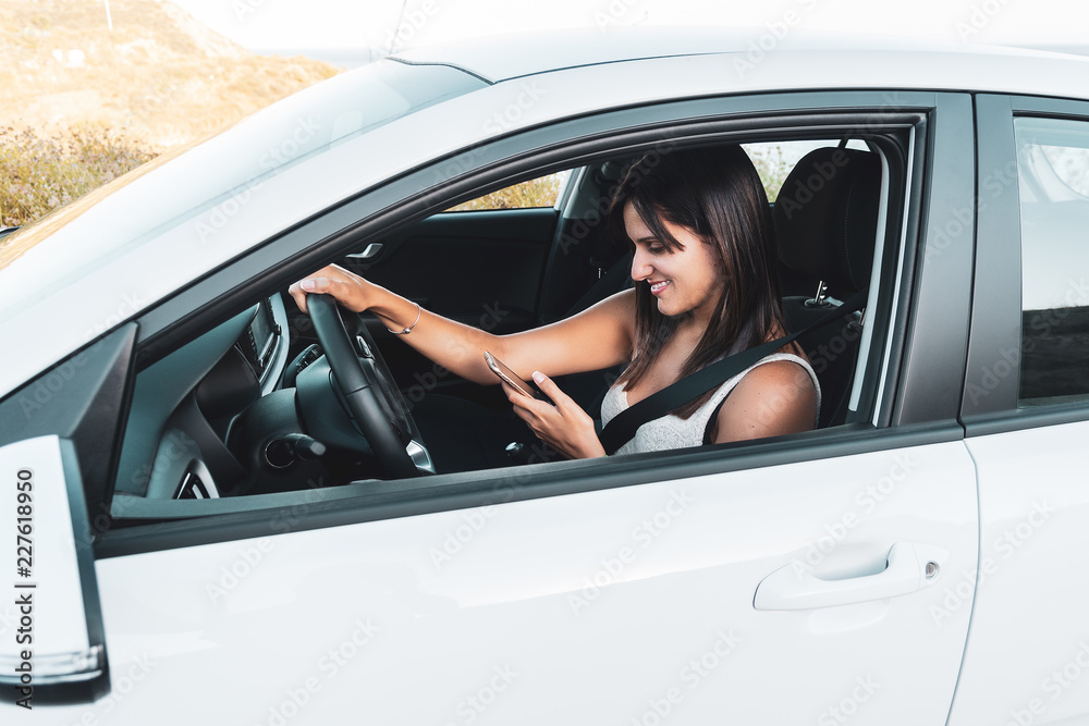 Young woman using a mobile phone in a car Young woman using a mobile phone in a car