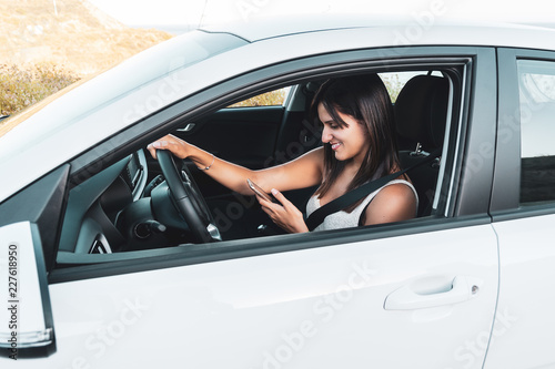 Young woman using a mobile phone in a car