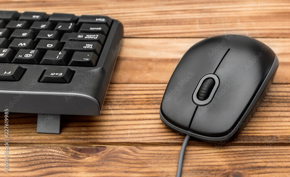 Computer keyboard with computer mouse on wooden table. Close up. Computer keyboard with computer mouse on wooden table. Close up.
