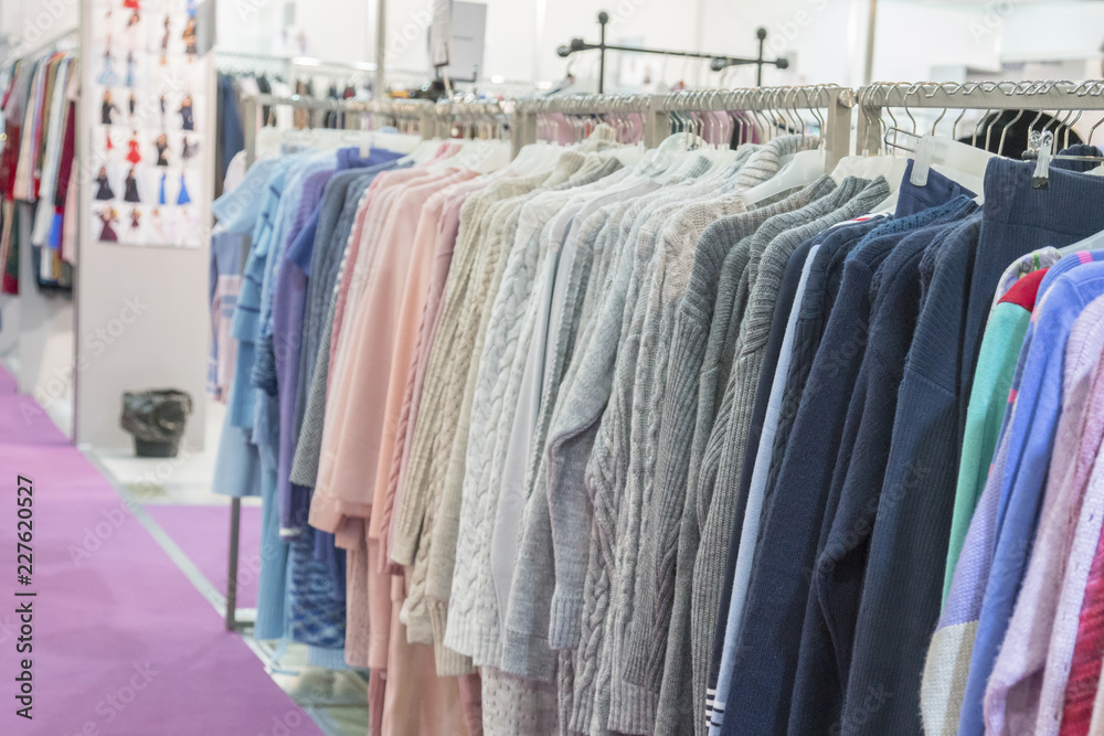 warm winter demi raglans on white shopping racks with silver metal parts on clothes shop. bright different clothes on the rack before sale season. new collection in clothes luxury shop warm winter demi raglans on white shopping racks with silver metal parts on clothes shop. bright different clothes on the rack before sale season. new collection in clothes luxury shop