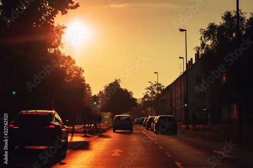 Driving in a urban road in the city at colorful orange sunrise morning