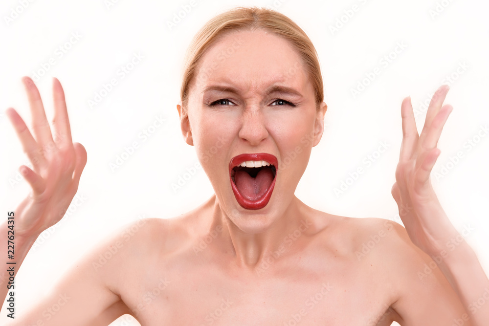 Beautiful blonde woman with pretty blue eyes and red lips. A scary female in pain holding her head and screaming in anger with an open mouth on her menstrual cycle period pain Beautiful blonde woman with pretty blue eyes and red lips. A scary female in pain holding her head and screaming in anger with an open mouth on her menstrual cycle period pain