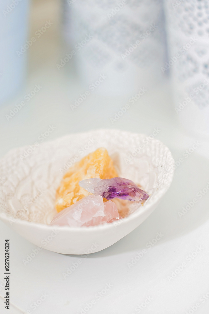 Healing crystals and gemstones on a white table: Amethyst Point, Calcite and rose quartz are bringing positive energy to support inner strength Healing crystals and gemstones on a white table: Amethyst Point, Calcite and rose quartz are bringing positive energy to support inner strength