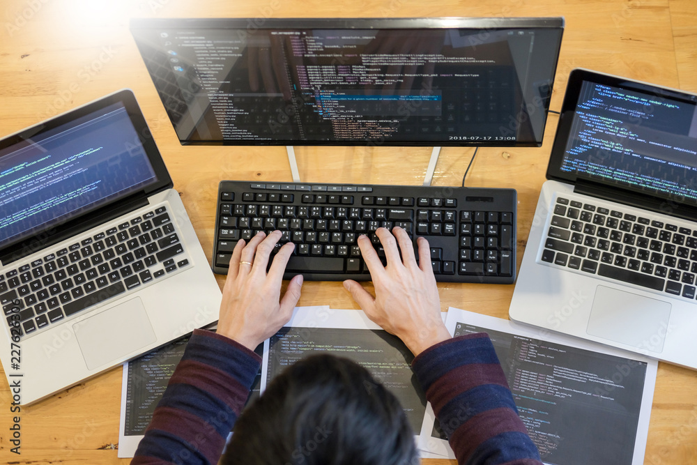 Fototapeta premium Pensive programmer working on on desktop pc programming code technologies or website design at office Software Development Company