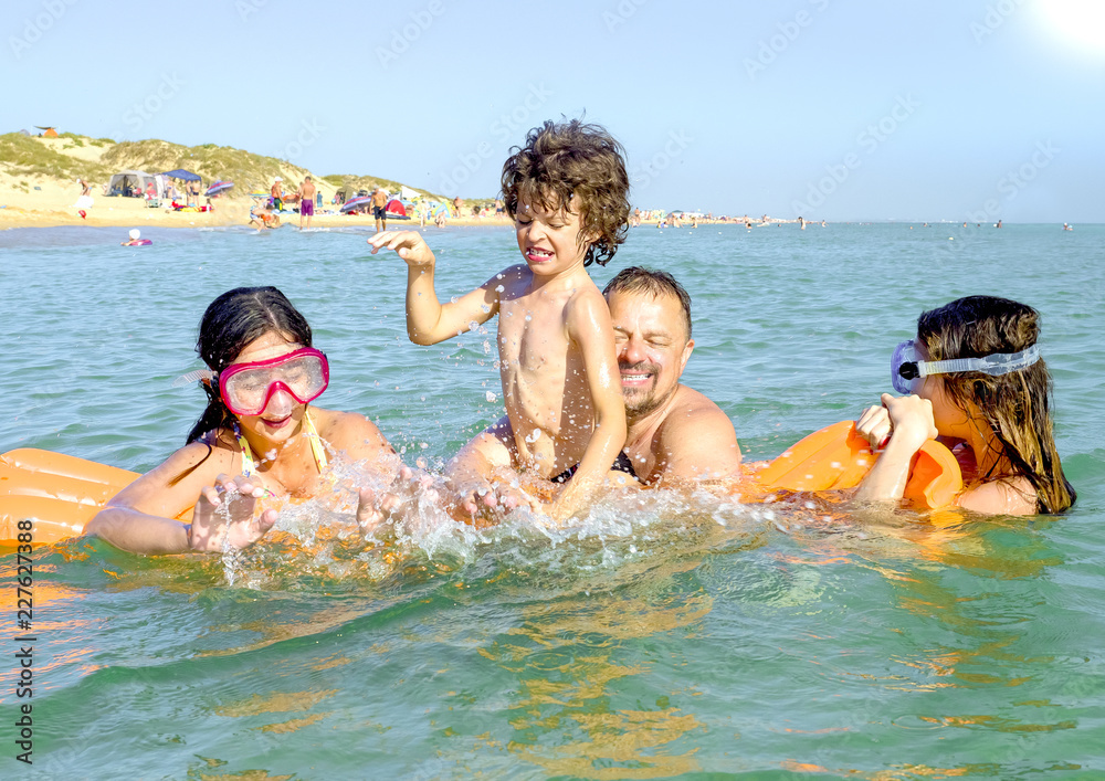 happy family with children is swimming and having fun in the sea on an inflatable mattress. happy friendly family concept happy family with children is swimming and having fun in the sea on an inflatable mattress. happy friendly family concept