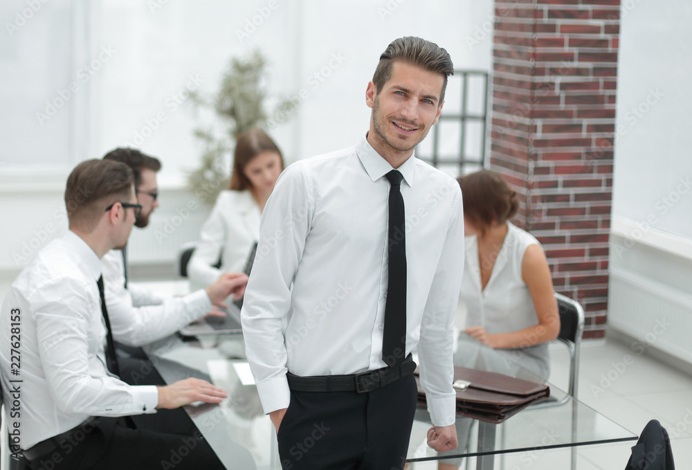 successful young businessman standing in the office successful young businessman standing in the office