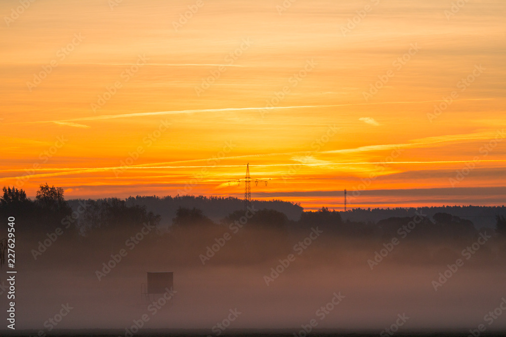Sunrise or sunset over a foggy field