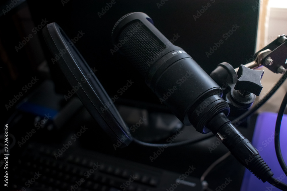 Closeup Black Microphone in home recording studio with pop shield on mic stand Closeup Black Microphone in home recording studio with pop shield on mic stand