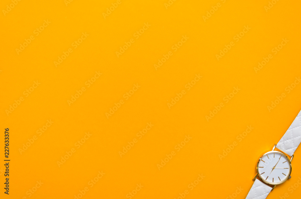 Whigte pocket watch in the corner of an orange background Whigte pocket watch in the corner of an orange background