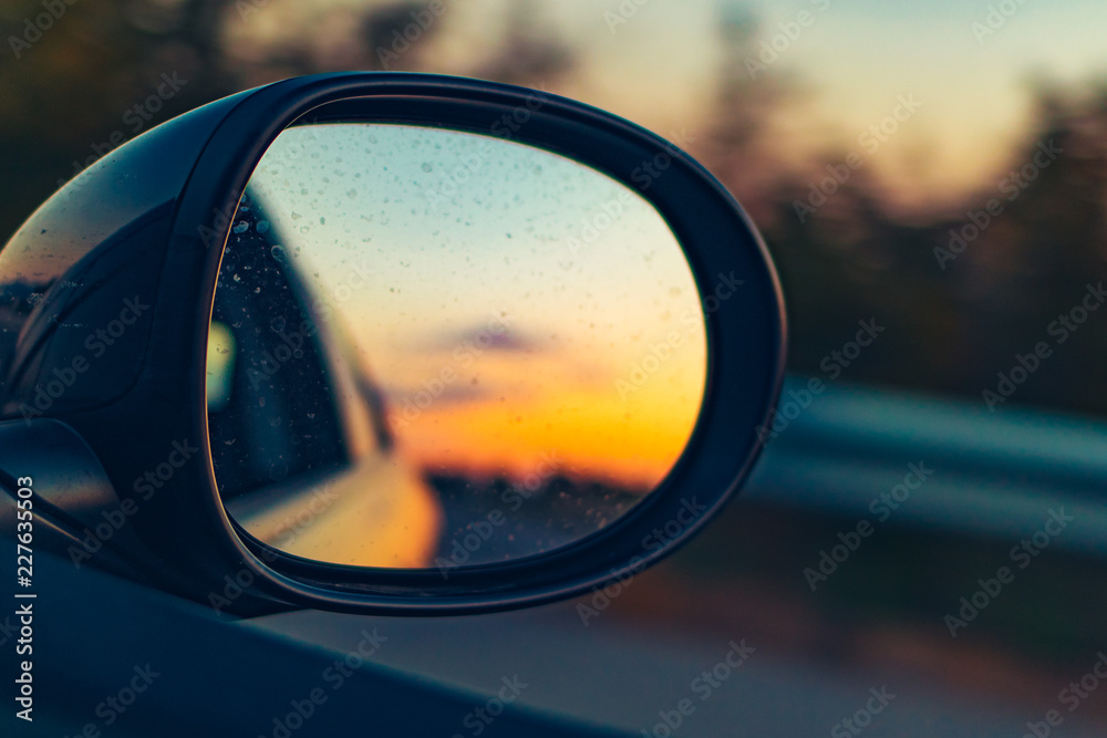Right mirror driving car on an orange sunset landscape Right mirror driving car on an orange sunset landscape