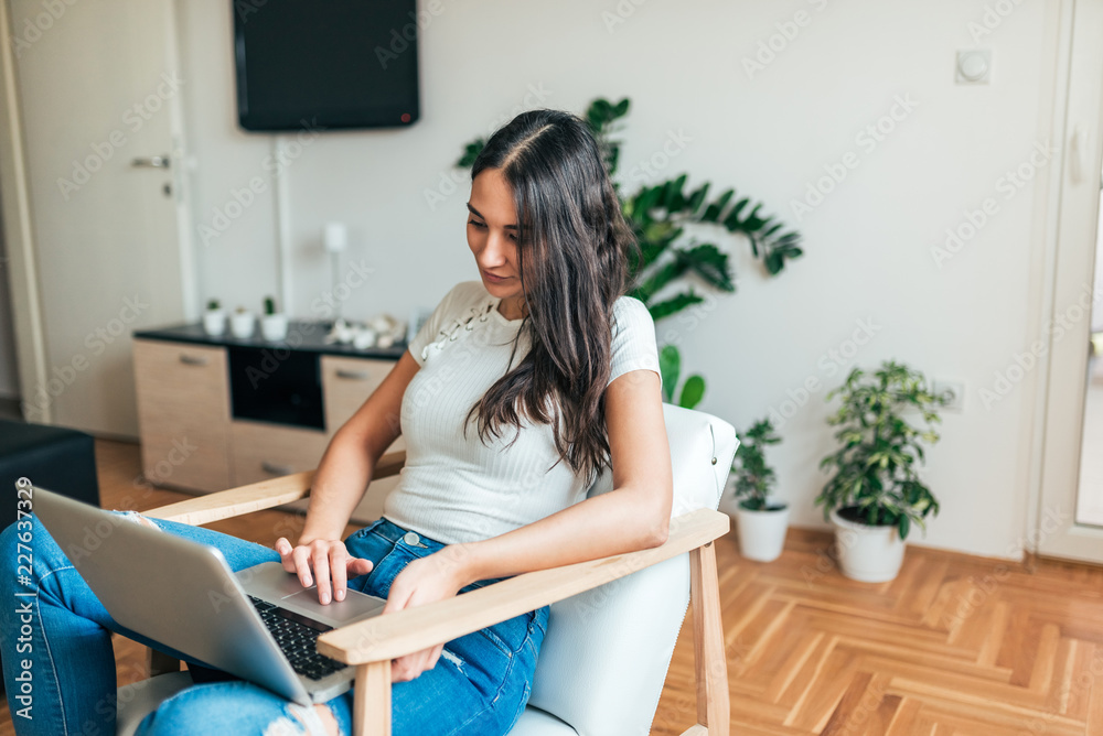Casual woman using laptop at home. Casual woman using laptop at home.