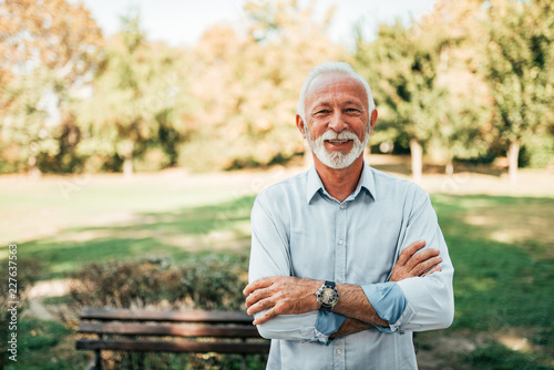 Portrait of a smiling older man in the park. photo