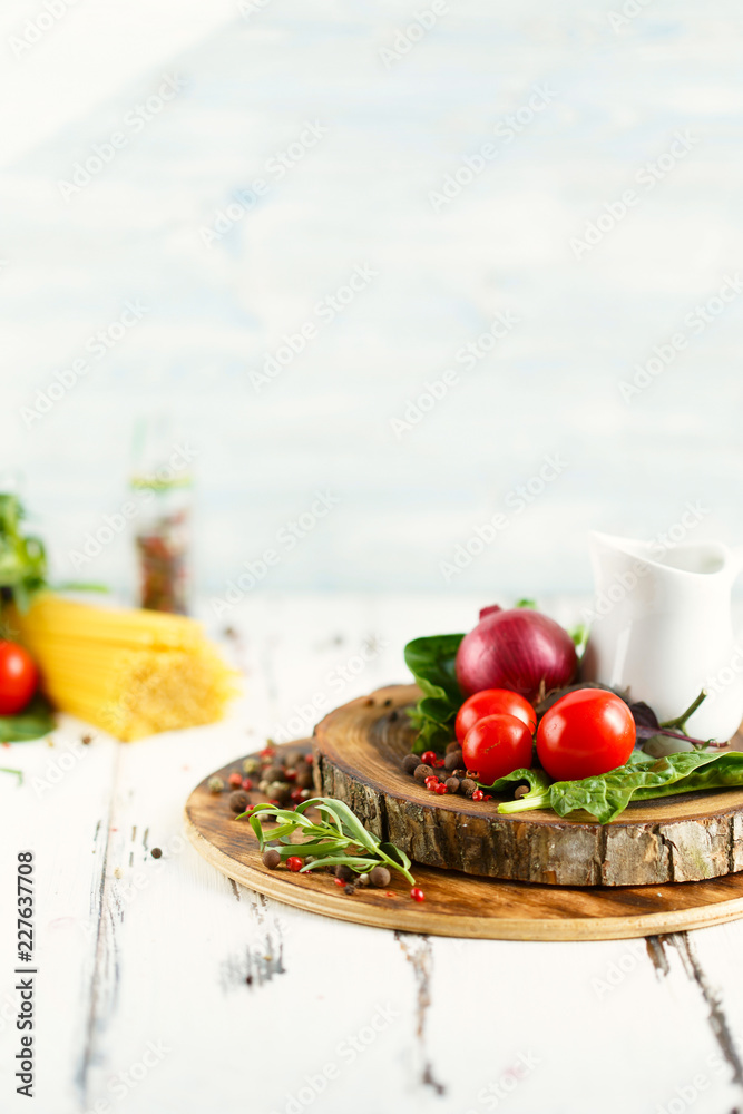 Cherry, tarragon, spaghetti, chili pepper, basil, spices Ingredients for cooking pasta. Food background on a white table Cherry, tarragon, spaghetti, chili pepper, basil, spices Ingredients for cooking pasta. Food background on a white table