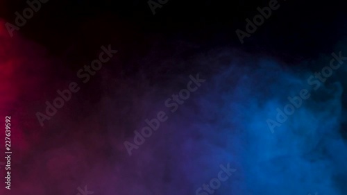 Abstract blurred smoke in red and blue colors over a black background in studio. 4K footage