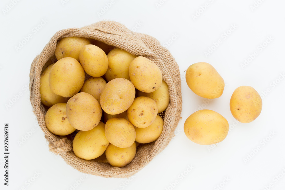 Sack of fresh raw potatoes on wooden background, top view Sack of fresh raw potatoes on wooden background, top view