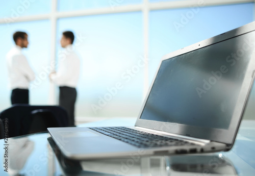 Close-up of office desk with business team behind