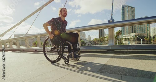Man using his wheelchair across a bridge