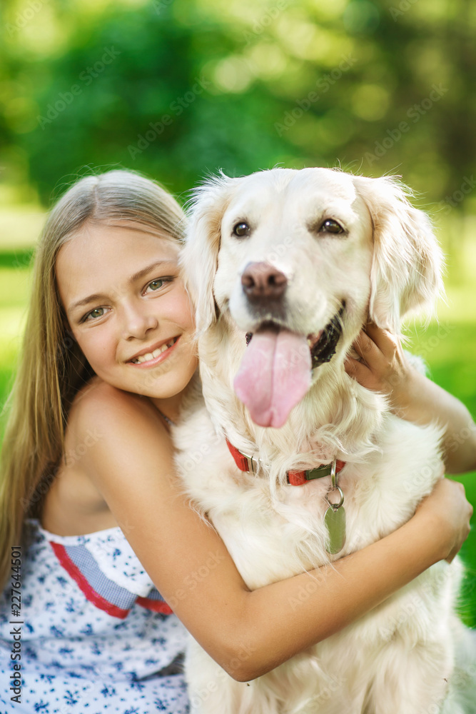Little girl with golden retriever dog in the park
