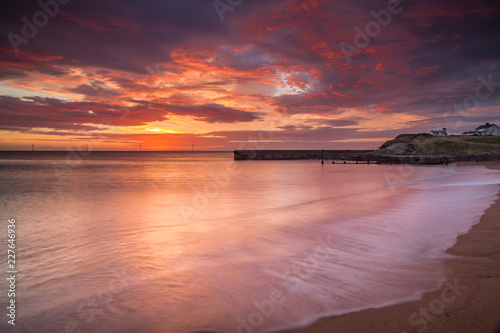 Sunrise over Seaton Sluice Beach and Harbour entrance on the coast of Northumberland, England, UK. © coxy58