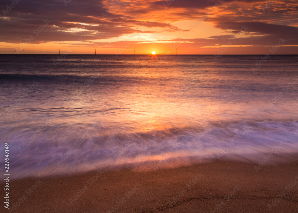 Sunrise over Seaton Sluice Beach and Harbour entrance on the coast of Northumberland, England, UK.