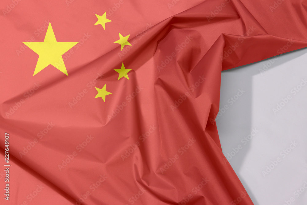 China fabric flag crepe and crease with white space, a large golden star within an arc of four smaller golden stars, in the canton, on a field of red. China fabric flag crepe and crease with white space, a large golden star within an arc of four smaller golden stars, in the canton, on a field of red.