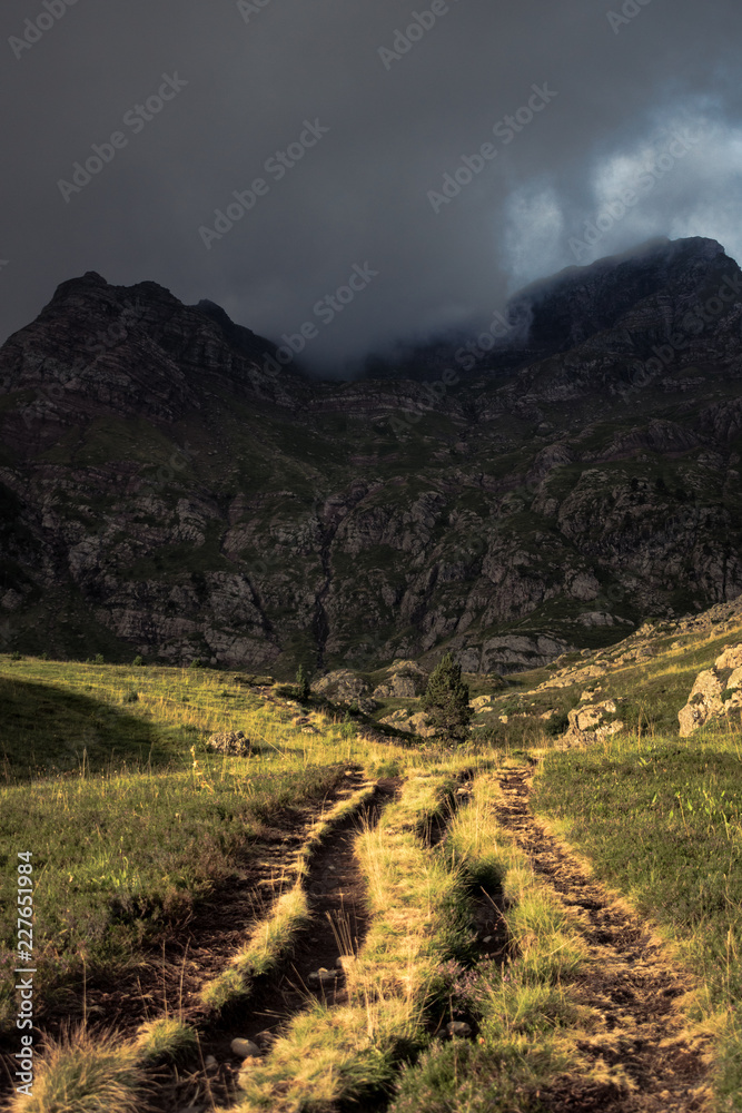 Fototapeta premium Chemin au soleil avec montagne en arriere plan, pyrénnées
