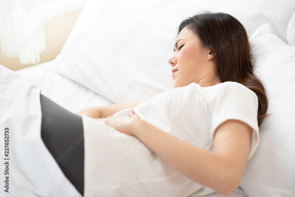 Asian woman stomachache on the white bed, feel pain Asian woman stomachache on the white bed, feel pain