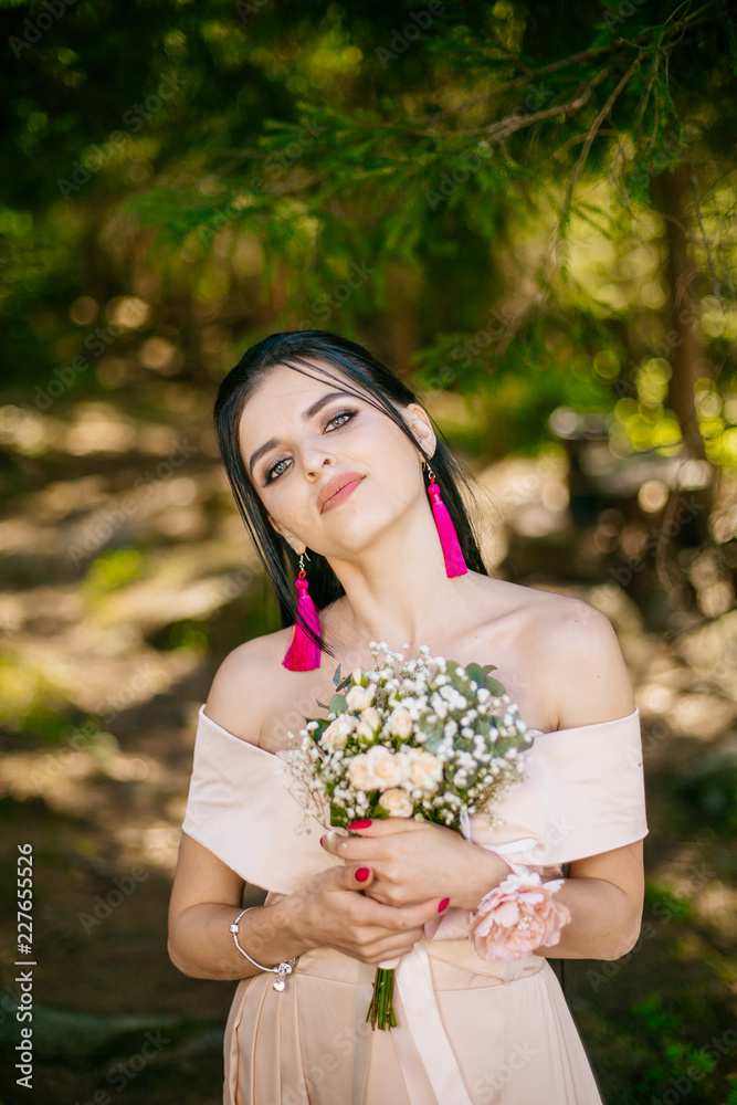 Portrait of beautiful and young bridesmaids with flowers outdoor. Two adorable girls embrace at forest park. Portrait of beautiful and young bridesmaids with flowers outdoor. Two adorable girls embrace at forest park.