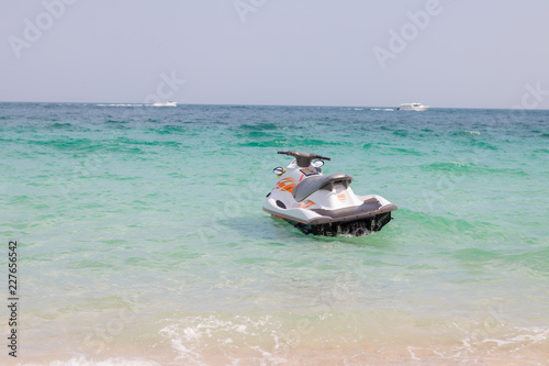 In the summer, white jet skis float in the blue sea. On a clear day.