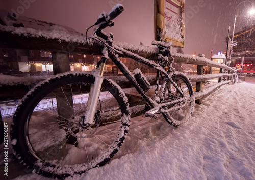 parked bicycle covered by snow