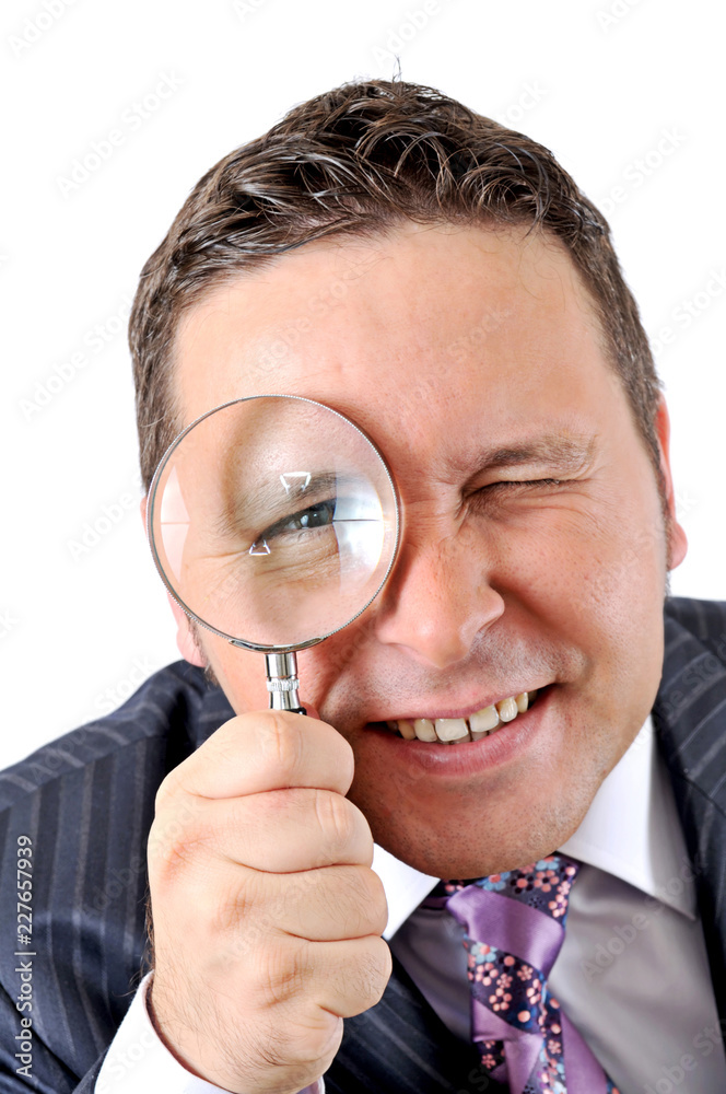 businessman in a suit looking through a magnifying glass businessman in a suit looking through a magnifying glass
