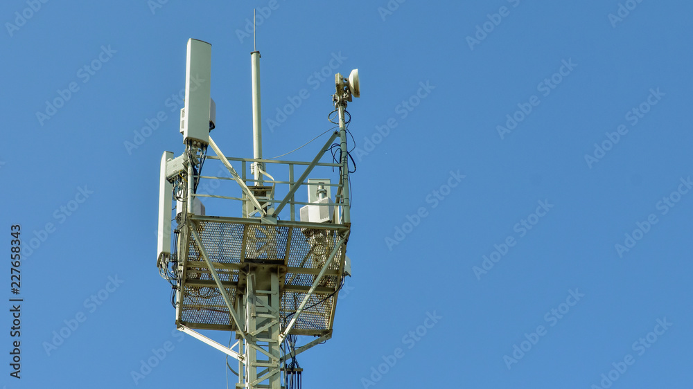 Cellular antenna tower against blue sky. Top of steel mast. copy space for text Cellular antenna tower against blue sky. Top of steel mast. copy space for text