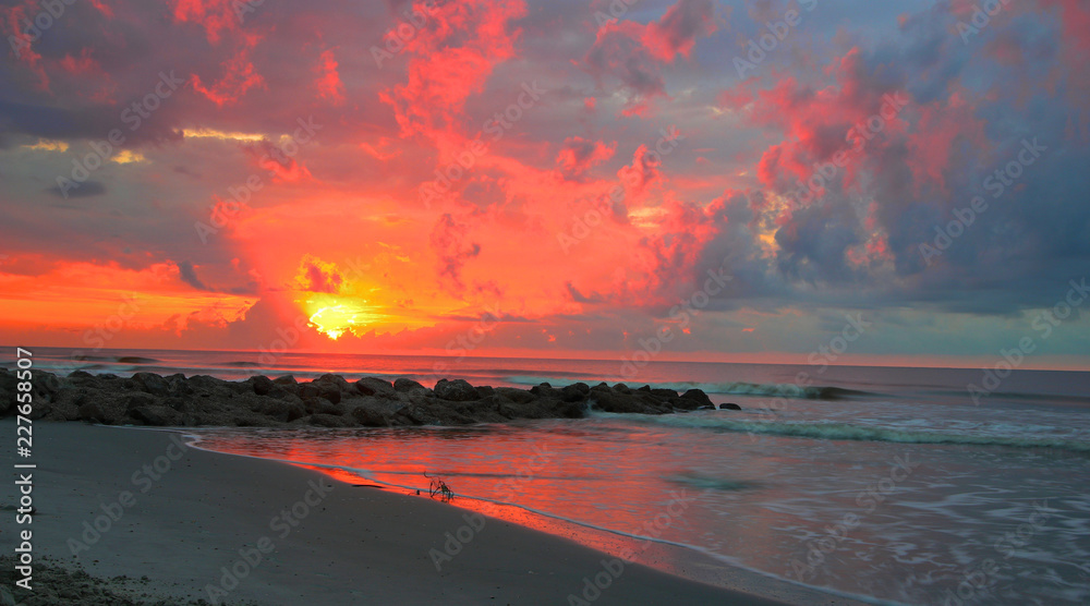 Sunrise over the sea and rocks Folly beach South Carolina