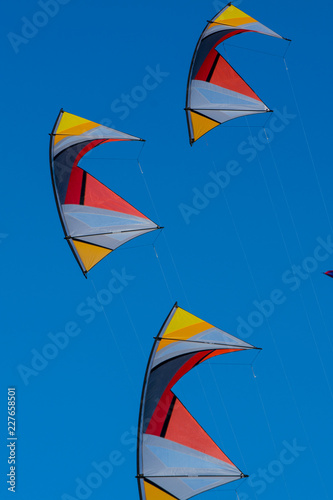 symmetry and color - kites are dancing in the wind, in a clear blue sky