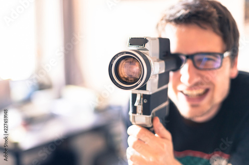 Junger Mann dreht mit Vintage/Retro-Kamera einen Film für ein Filmfestival 