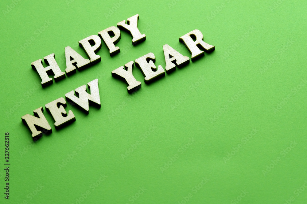 Obraz premium Woden letters new year on the green background.
