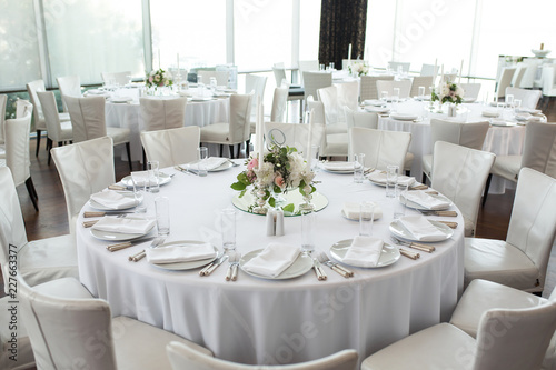 wedding banquet table served and decorated with fresh flowers and white candles. Wedding decoration concept © Kate