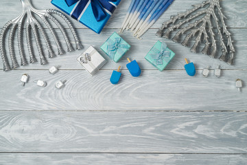 Jewish holiday Hanukkah background with menorah, spinning top and gift box on wooden table