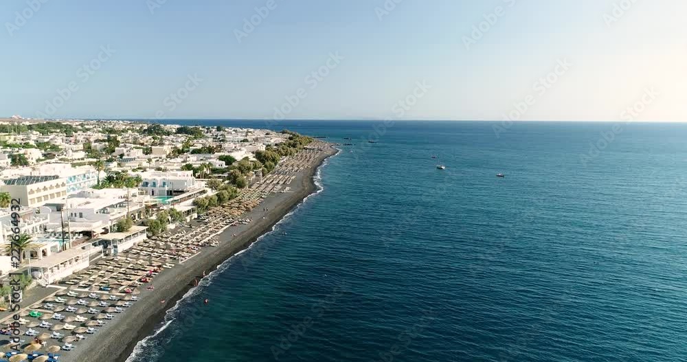 private beach with umbrella on the island of Santorini in aerial view private beach with umbrella on the island of Santorini in aerial view
