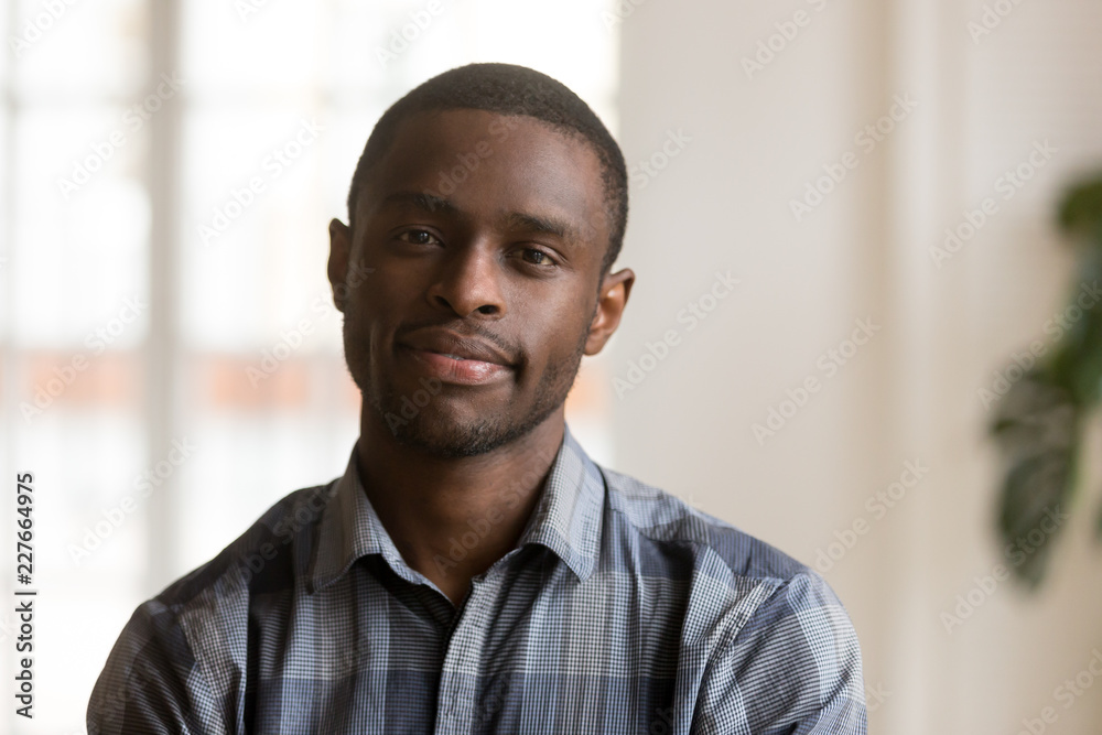 Head shot of confident young handsome black man looking at camera. Portrait  African American single bachelor male standing posing in living room at  home. Successful millennial wellbeing person concept Stock Photo