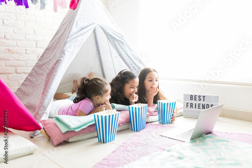 Little Friends Enjoying Snacks While Watching Movie In Laptop In A Tent