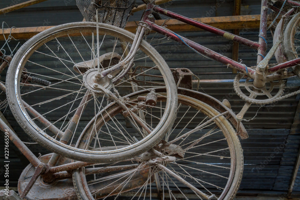 Unused old and dusty retro bicycle hanging under metal roof of home background. Unused old and dusty retro bicycle hanging under metal roof of home background.