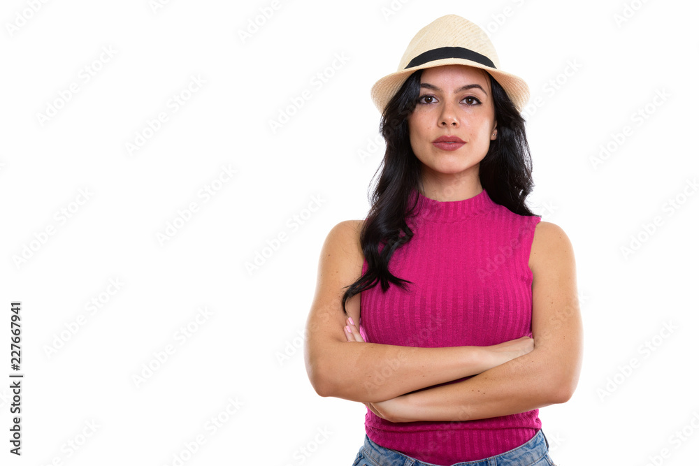 Studio shot of young beautiful Spanish woman wearing hat with ar Studio shot of young beautiful Spanish woman wearing hat with ar
